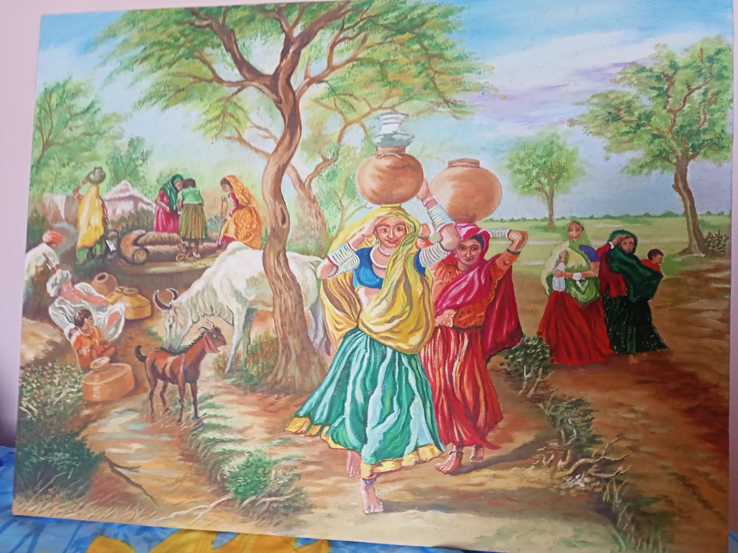 Women carrying water pots at a rural well in colourful sarees